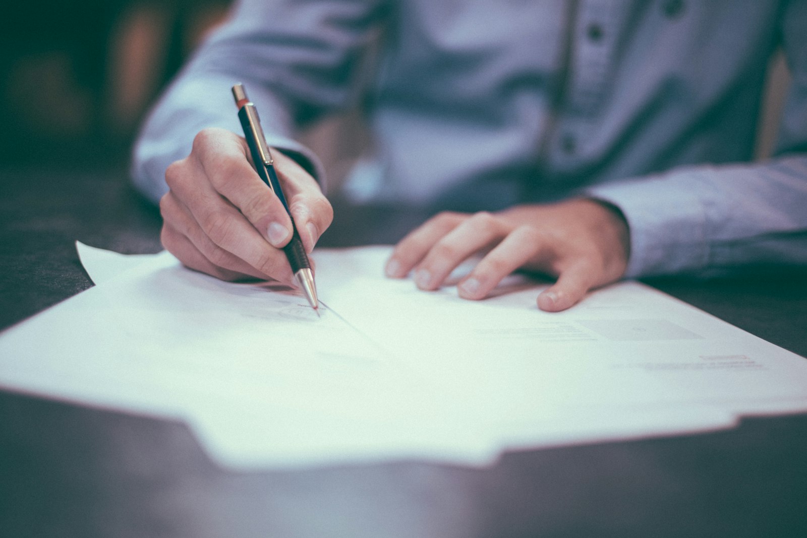A UK SME owner's office desk with management accounts and notes prepared for a free business valuation.